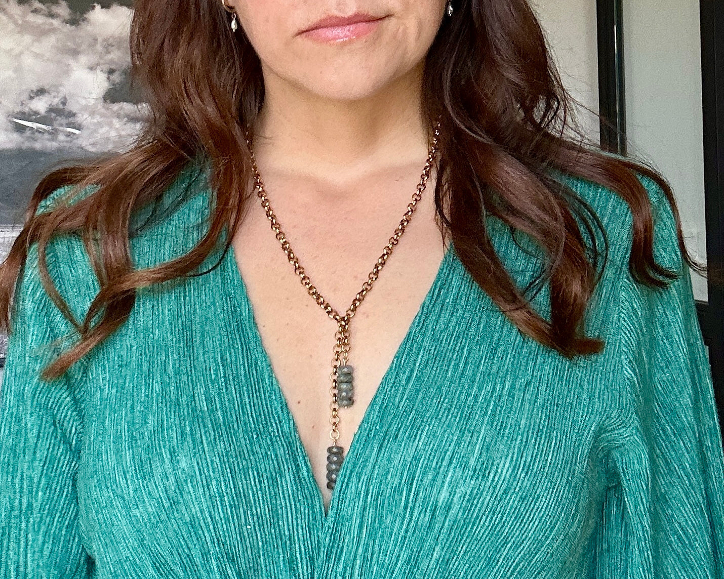 Rochelle labradorite lariat necklace styled with a green wrap v-neck top, close-up of the beaded drop