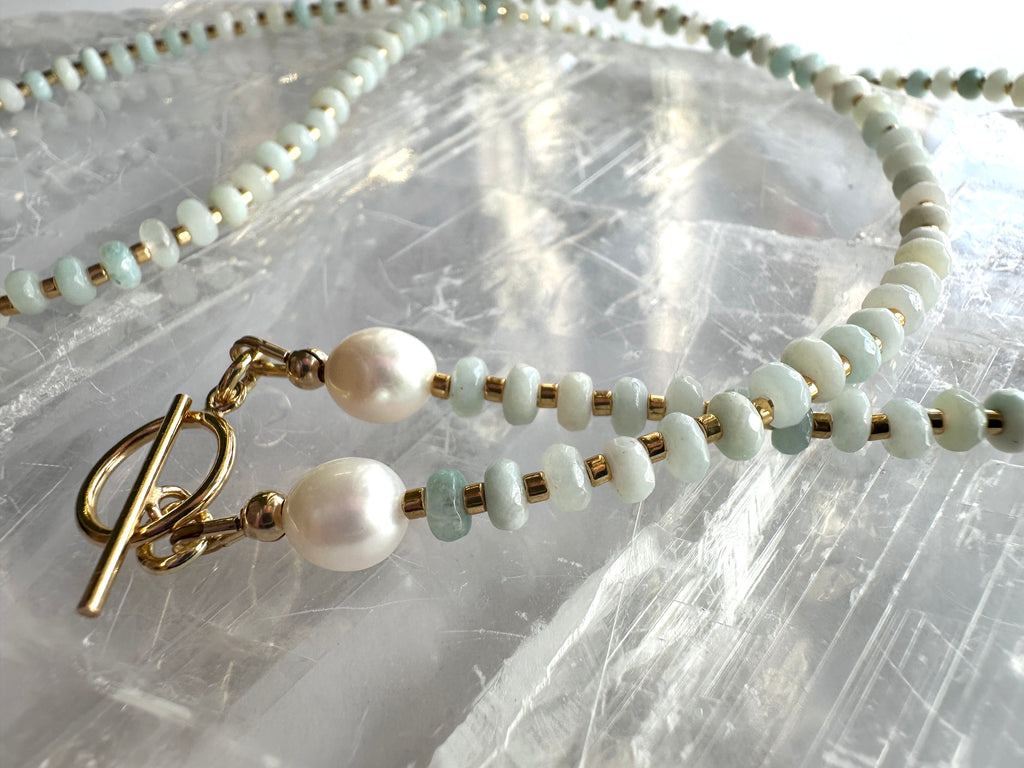 Two lengths of the Amara necklace by Auréad Designs displayed on a white selenite slab, showing amazonite beads, freshwater pearls, gold spacer beads, and the 14k gold-filled toggle clasp