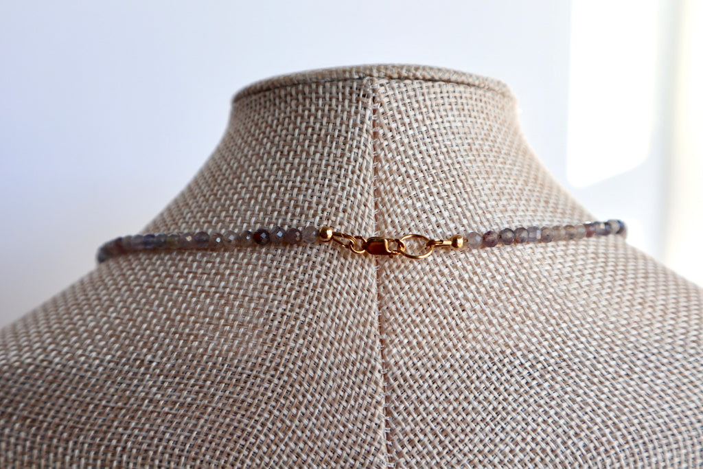 Astrielle necklace by Auréad Designs displayed on a linen bust form from the back, showing the 14k gold-filled lobster clasp and the delicate iolite bead strand