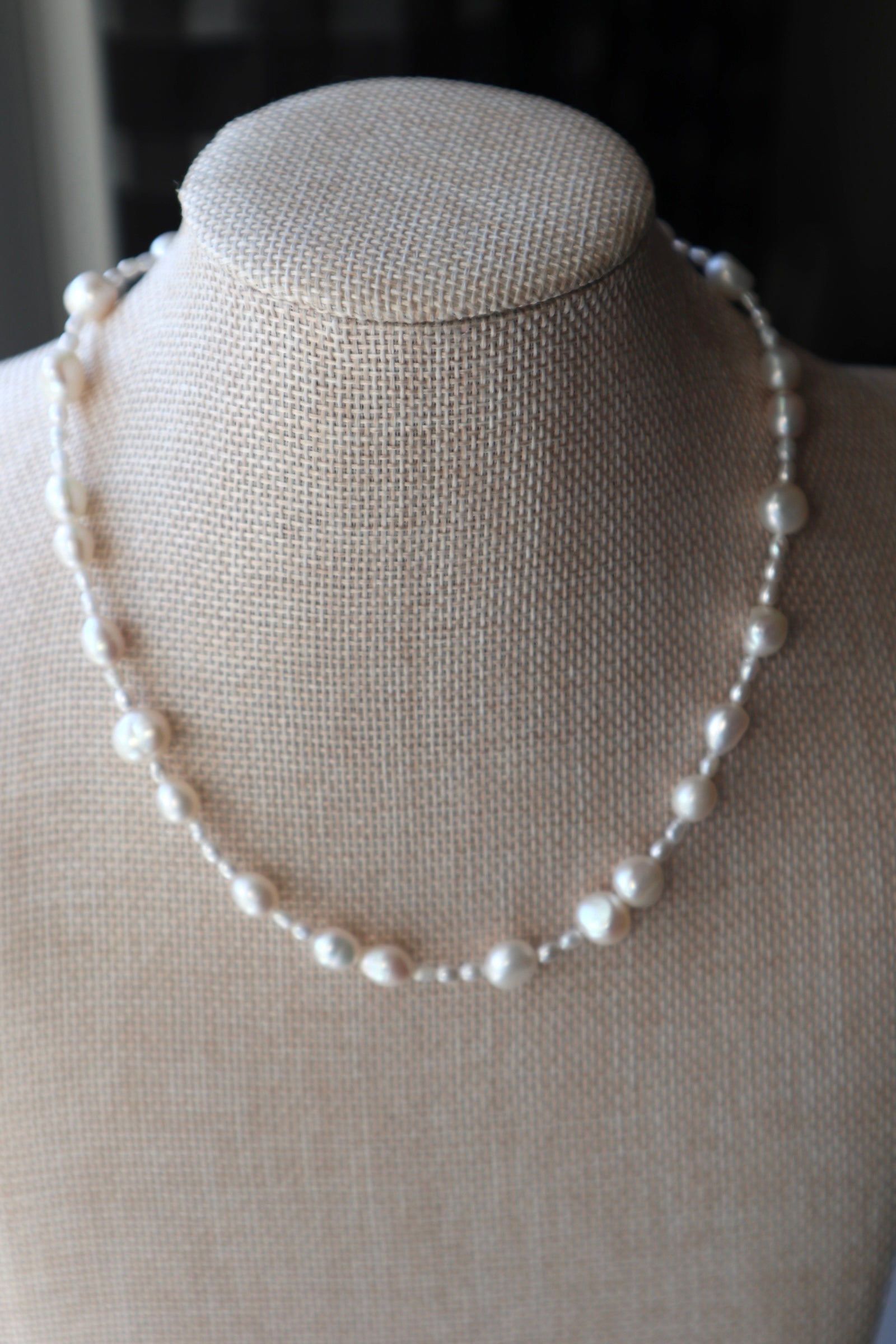 Aveline necklace by Auréad Designs displayed on a linen bust form, showing the full strand of mixed freshwater rice and nugget pearls with organic variation in shape and size