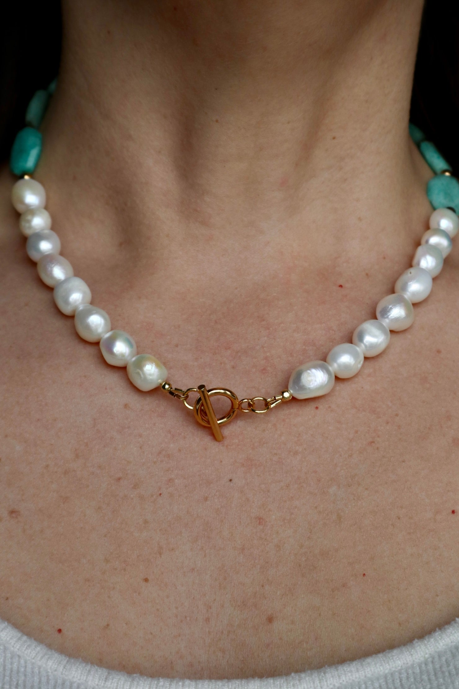 Azurea Maren amazonite and freshwater pearl necklace by Auréád Designs worn on a bare neckline, with baroque freshwater pearls centered at the front and a gold toggle clasp