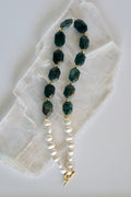Azurea necklace by Auréad Designs, featuring vivid blue apatite gemstone beads and freshwater pearls with gold-filled spacer beads and a toggle clasp, laid flat on a white selenite slab
