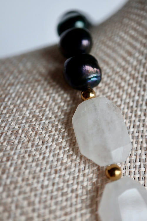 Close-up of the Azurea Noir necklace showing the contrast between light-catching clear quartz beads and rich black pearls with gold stainless steel spacer beads