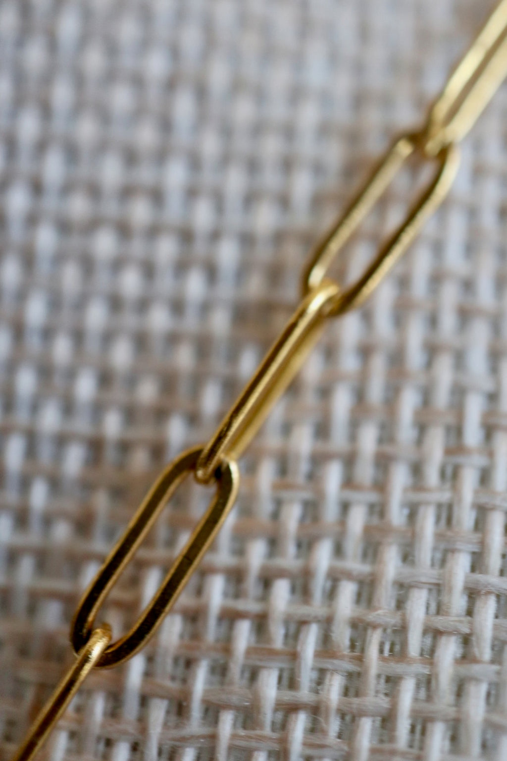 Auréad Designs Caelova lariat necklace close-up of gold stainless steel paperclip chain links on linen bust form