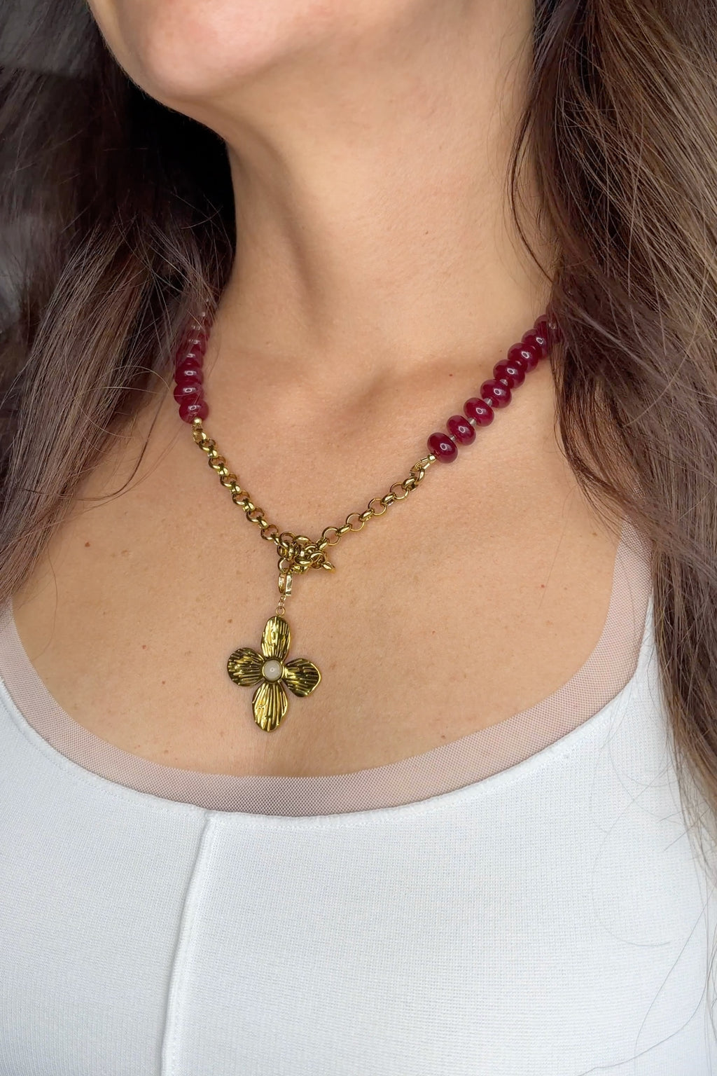 Carmina red jade necklace with gold flower pendant by Auréad Designs, worn with knotted rolo chain and white top