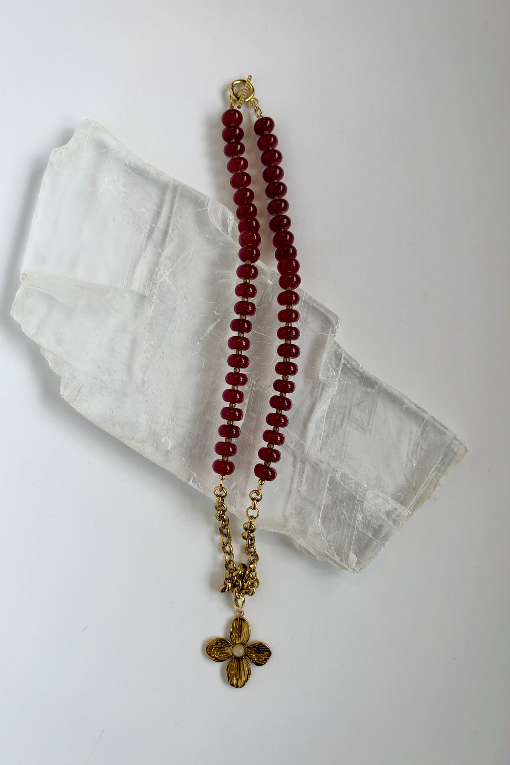 Carmina red jade and gold stainless steel rolo chain necklace by Auréad Designs on white selenite slab