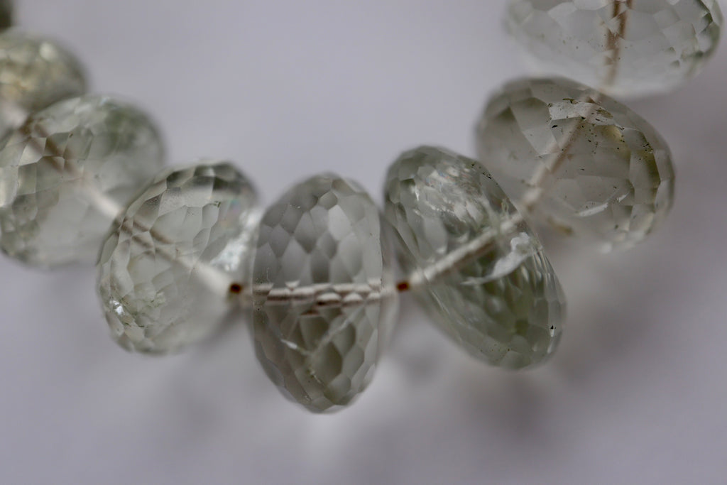 Macro close-up of the Clarae necklace showing the intricate faceting and natural translucency of the graduated green quartz gemstone beads with their subtle inclusions and soft green tones
