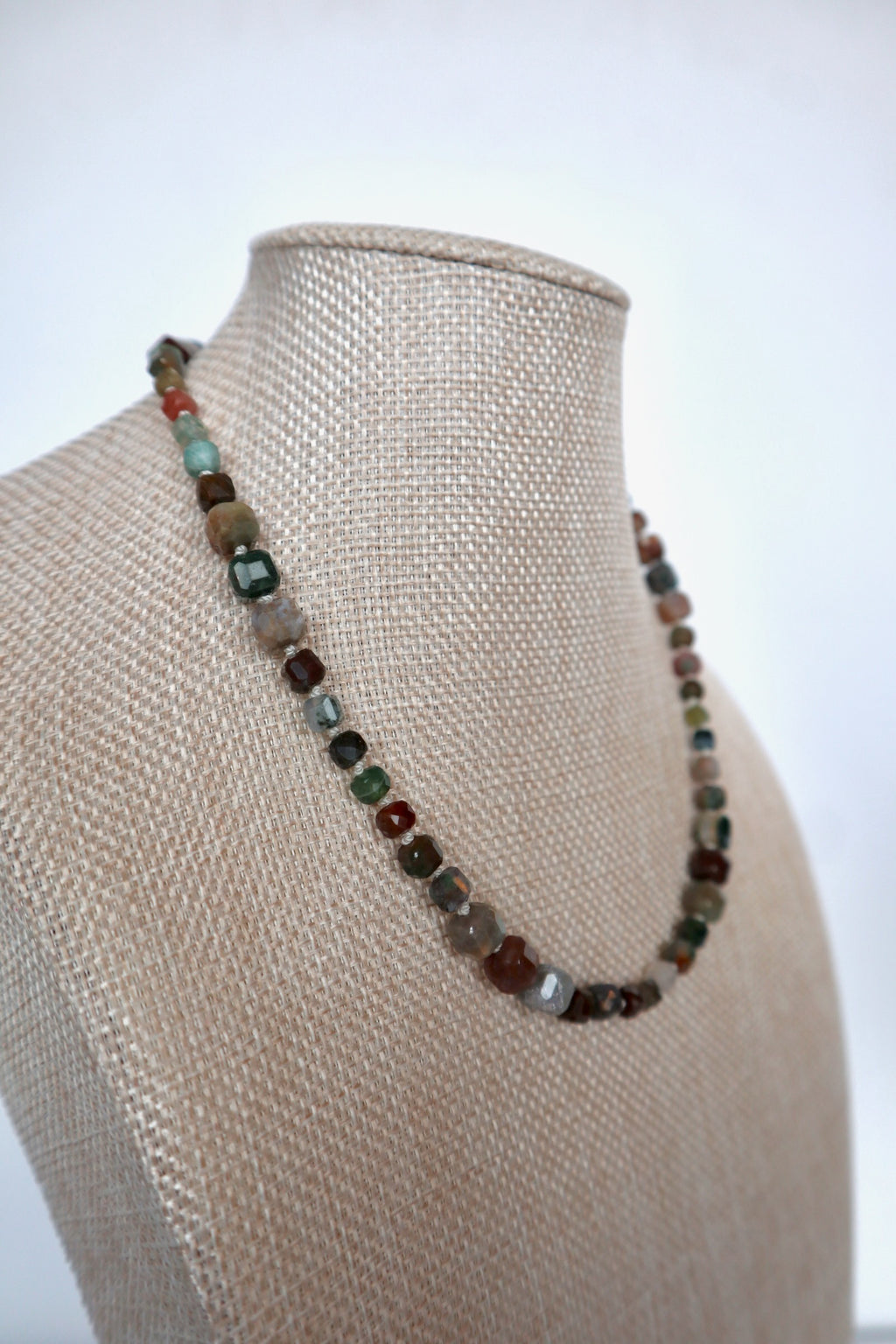 Current necklace by Auréad Designs displayed on a linen bust, full-length view of the silk-knotted indian agate beads in multicolored natural tones