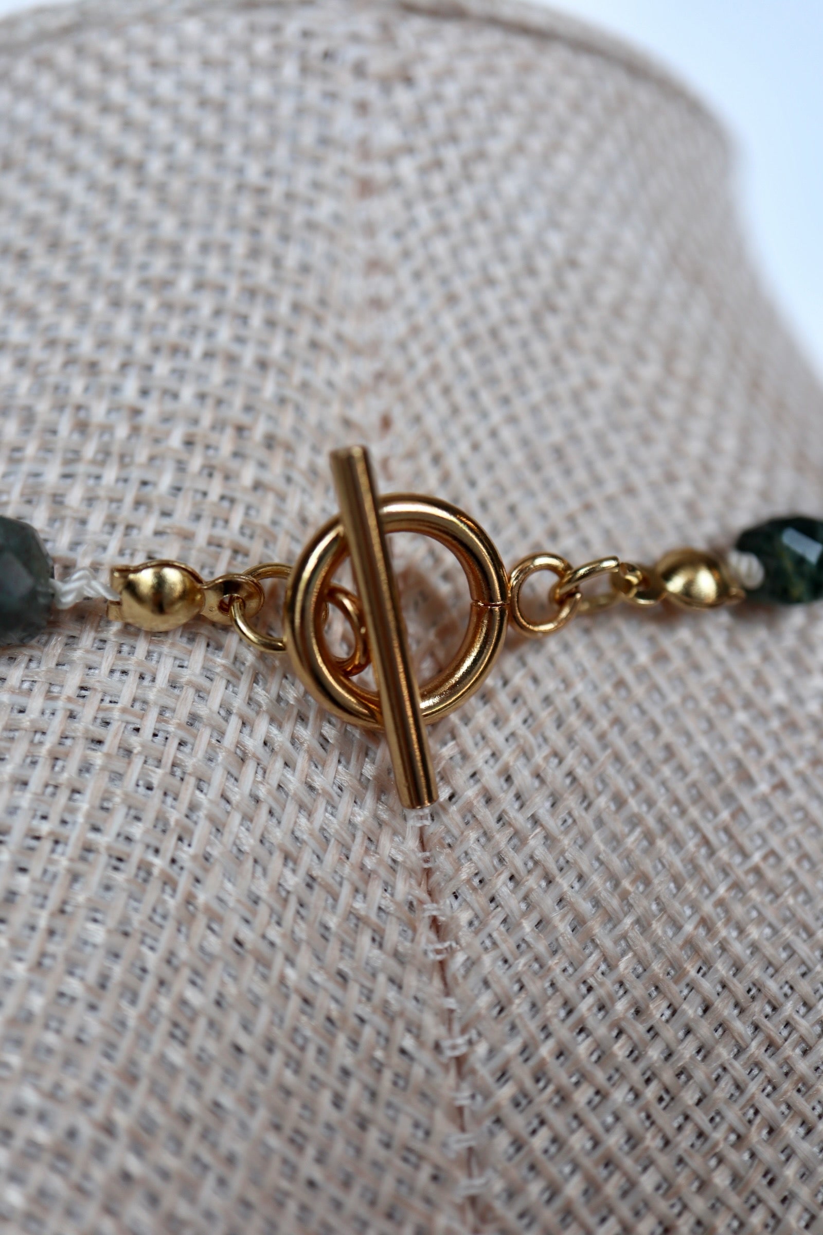 Close-up of the gold toggle clasp on the Current necklace by Auréad Designs, handmade indian agate beads silk knotted on either side