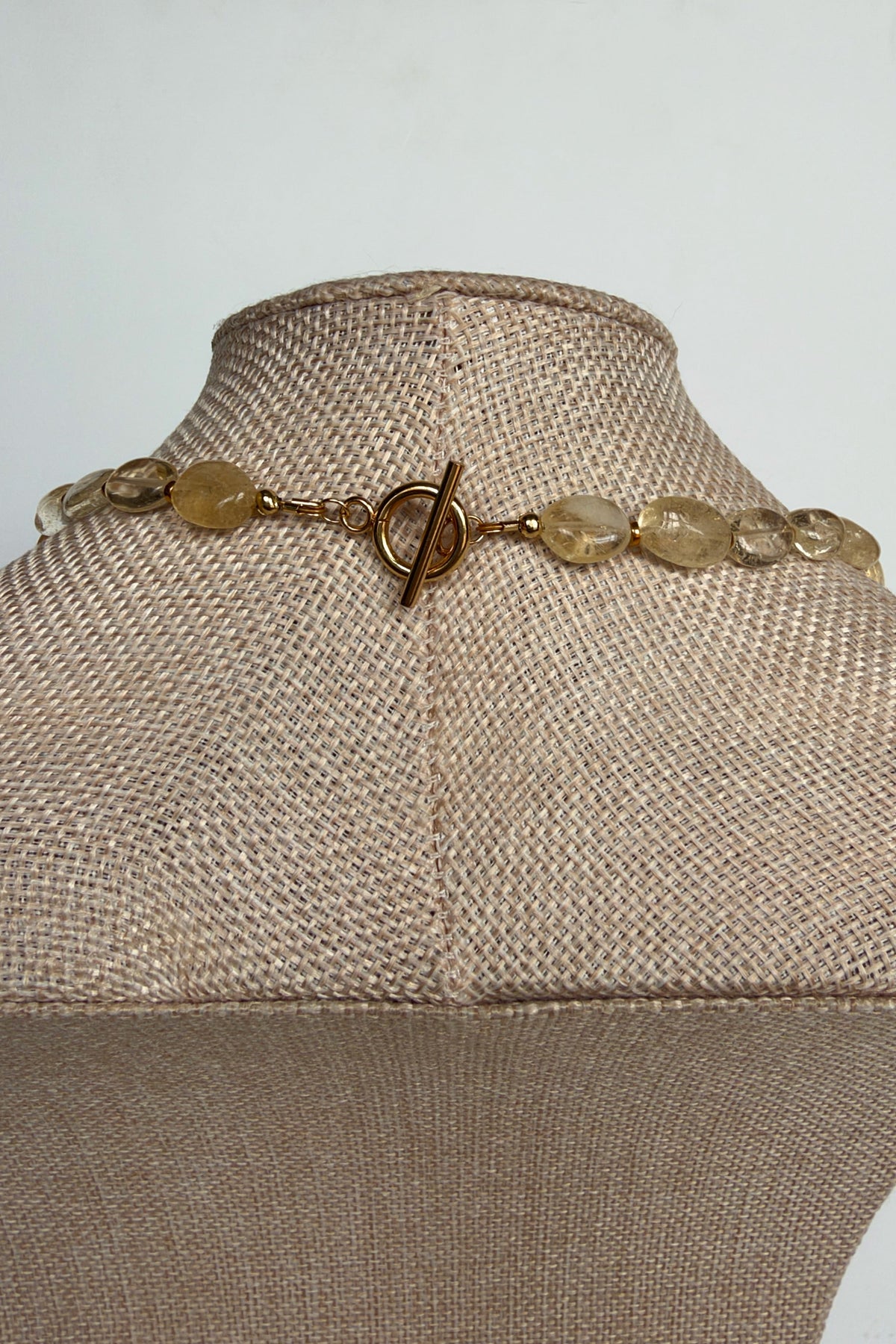 Dawn citrine and freshwater pearl necklace by Auréad Designs, close-up of gold stainless steel toggle clasp worn in front