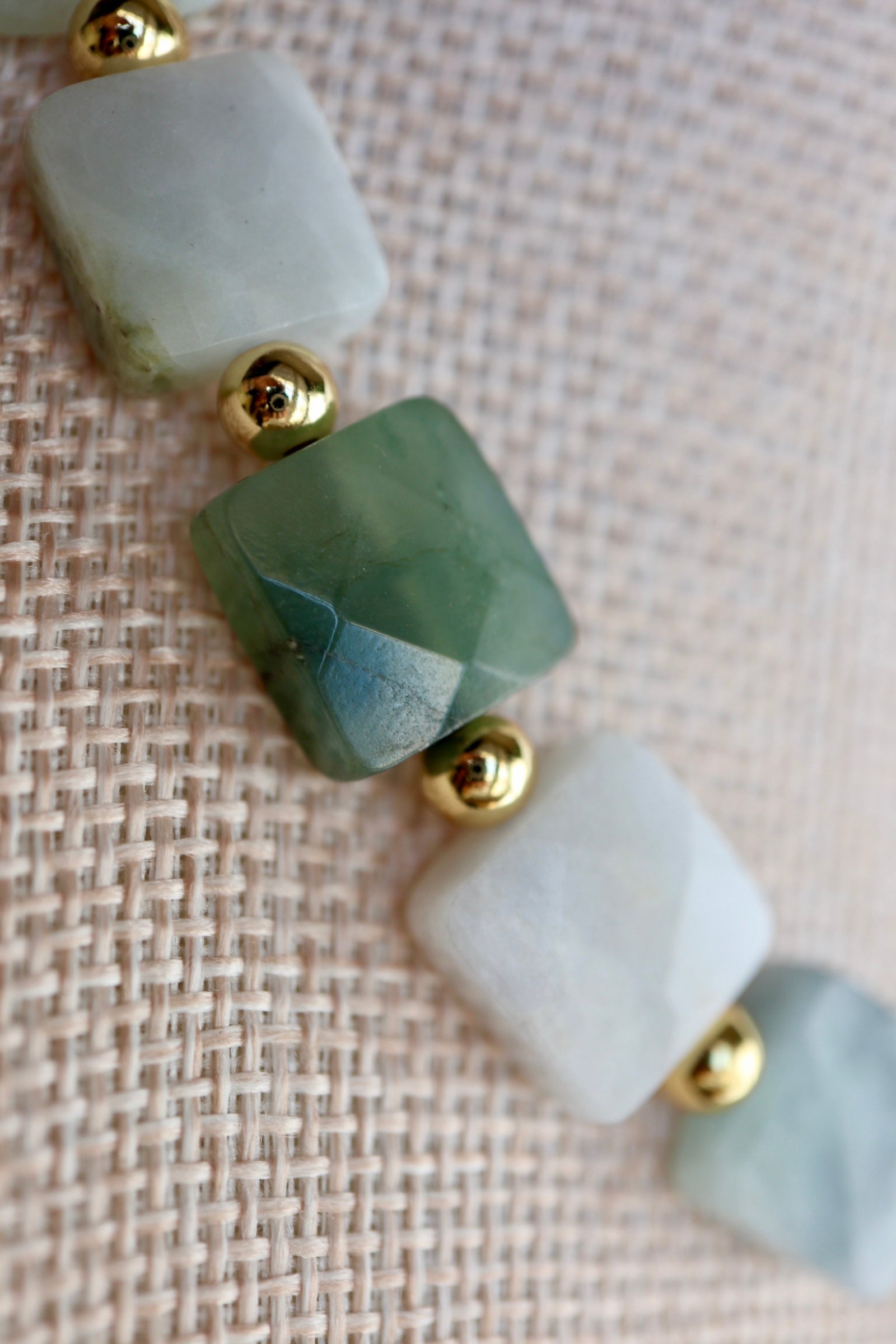 Close-up of the Everra necklace highlighting the geometric square cut and rich green tones of the nephrite jade beads alongside gold stainless steel spacers