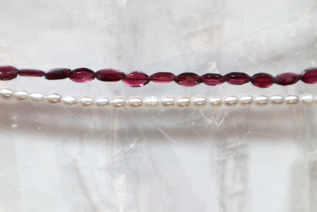Close-up of the Garnelle necklace showing the deep red marquise garnet beads and luminous freshwater pearl accents along the strand