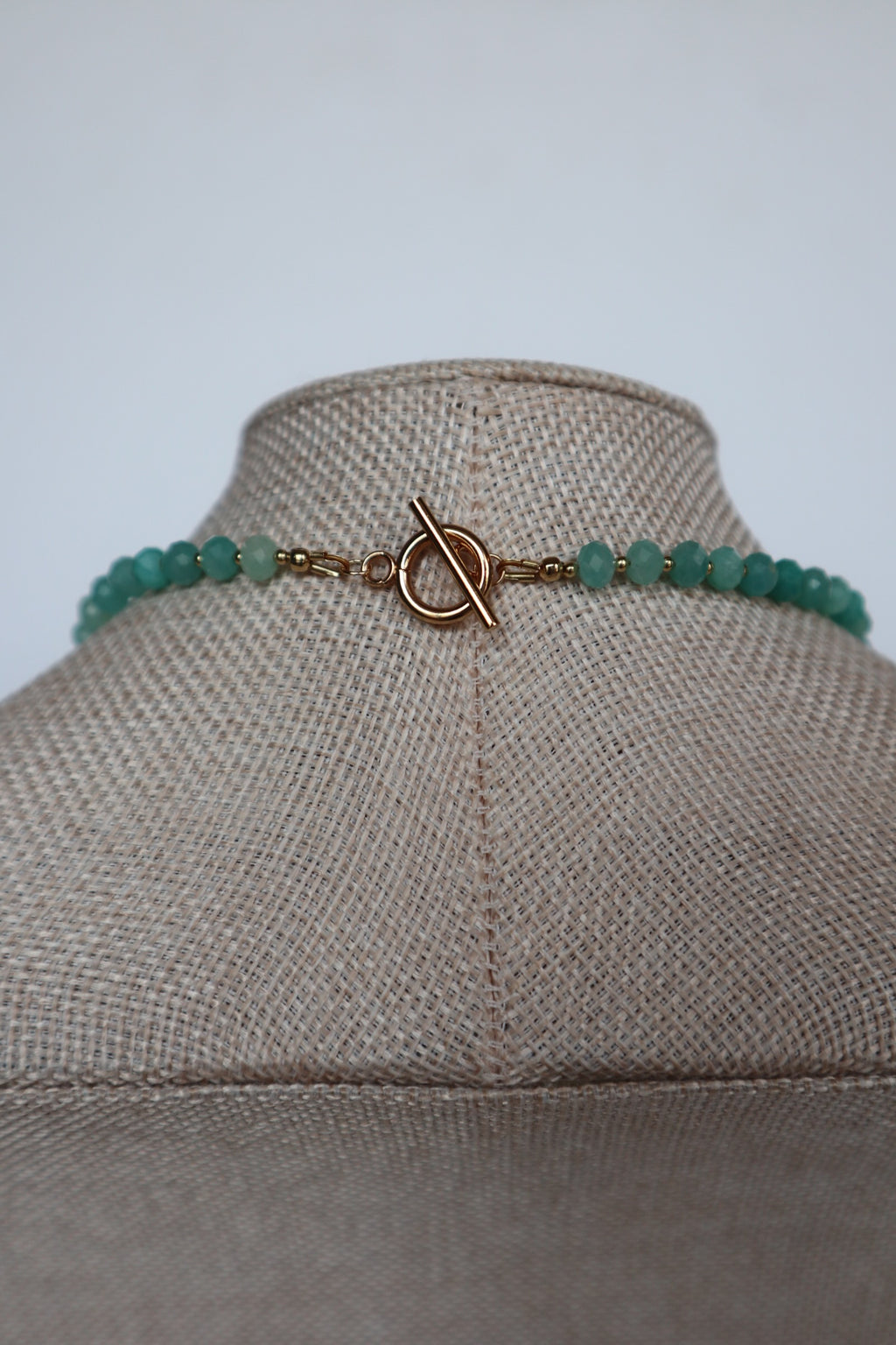 Close-up of the gold toggle clasp on the Lake necklace by Auréad Designs, with amazonite rondelles and gold spacer beads on either side
