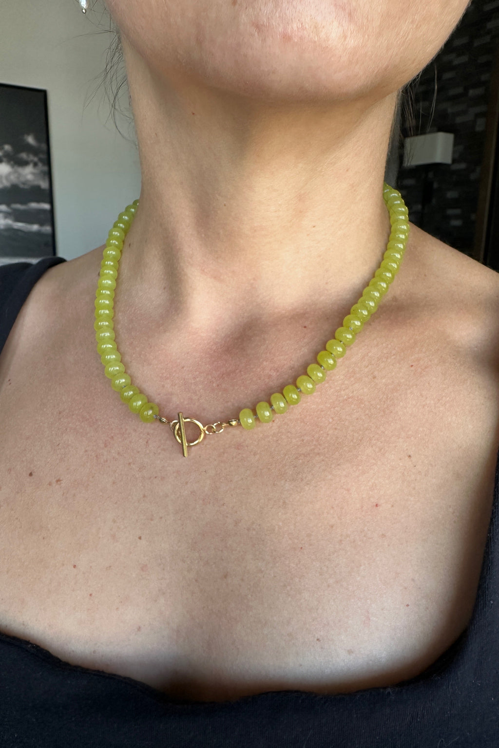 Ledge necklace by Auréad Designs worn at the neck with gold toggle clasp centered at the front, bright lemon jade rondelles against skin, from the Glacier Collection