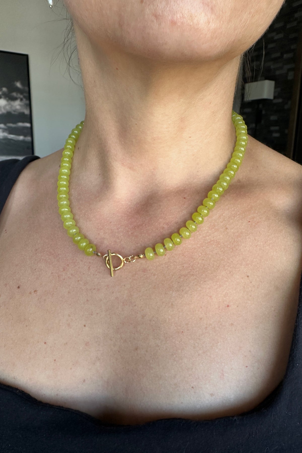 Ledge necklace by Auréad Designs worn at the neck with gold toggle clasp centered at the front, bright lemon jade rondelles against skin, from the Glacier Collection