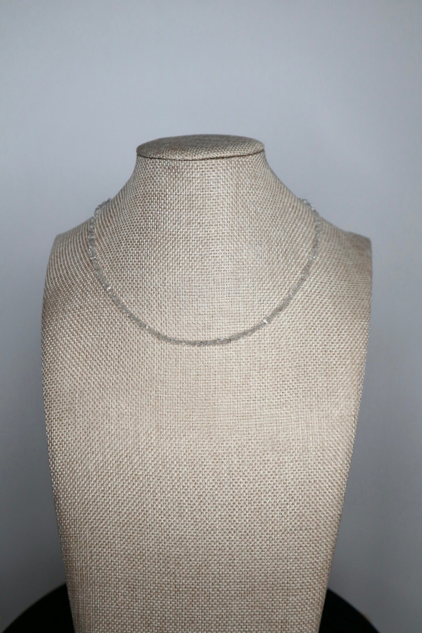 Lumenne herkimer diamond chip necklace by Auréád Designs displayed on a linen bust form, a delicate 16-inch strand of icy faceted crystals with 14k gold-filled findings