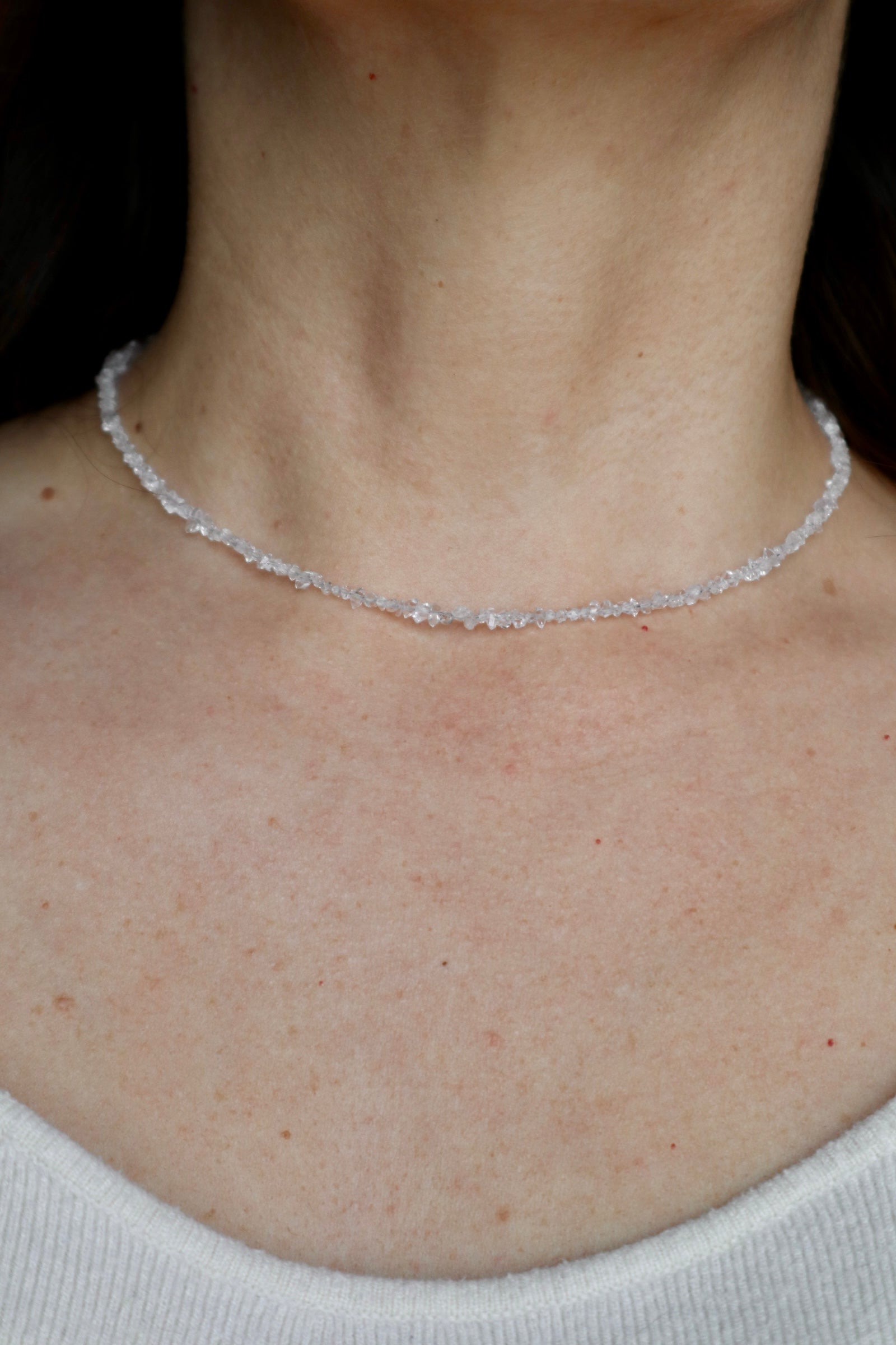 Lumenne herkimer diamond chip necklace by Auréád Designs worn on a bare neckline, a delicate strand of icy faceted crystals sitting close to the collarbone