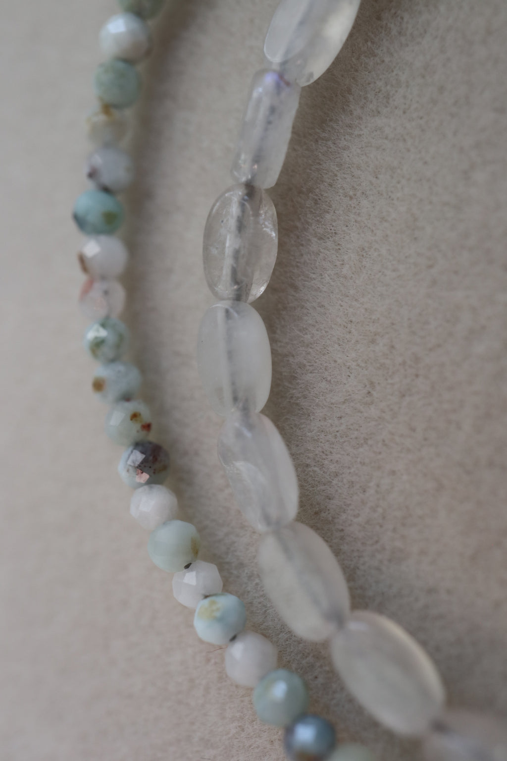 Close-up of the Lunamar necklace showing the cool blue tones of micro-faceted larimar beads alongside flat oval rainbow moonstone