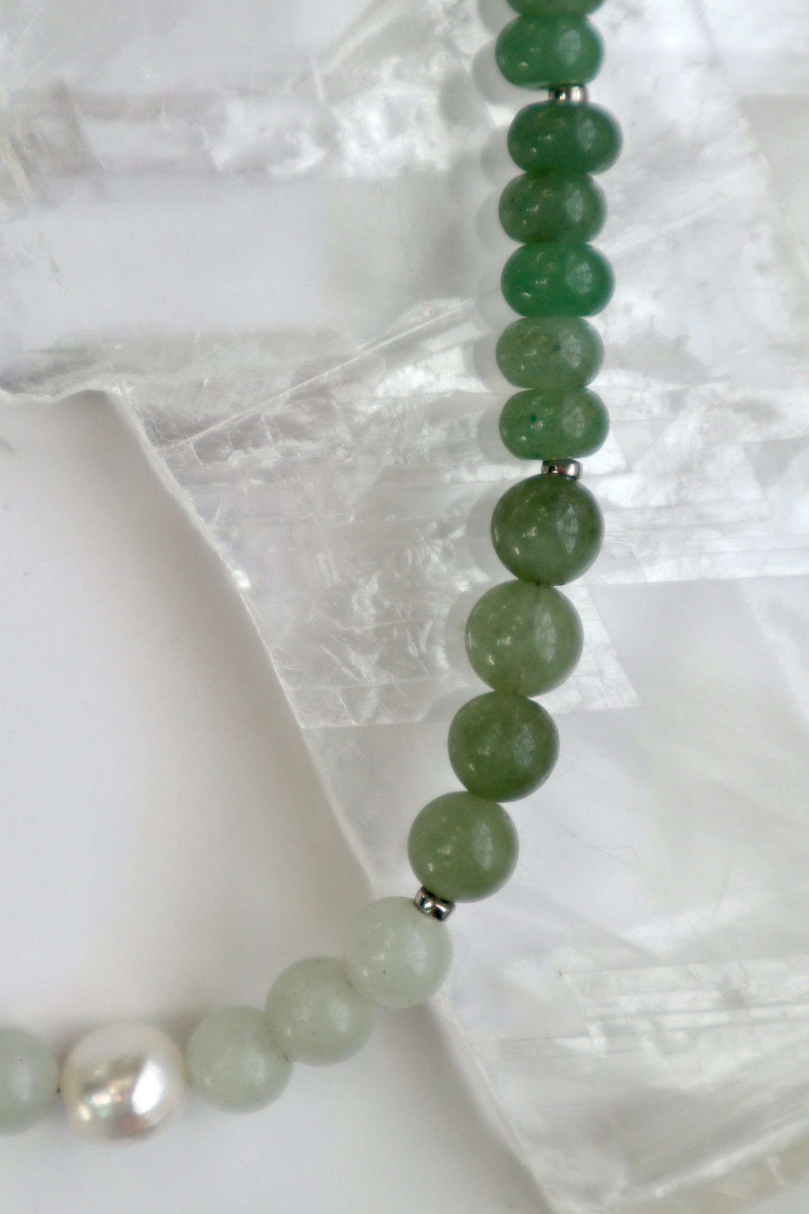 Close-up of the Meadowe necklace showing the layered green tones of jade beads alongside grape agate and the soft glow of the freshwater pearl accent