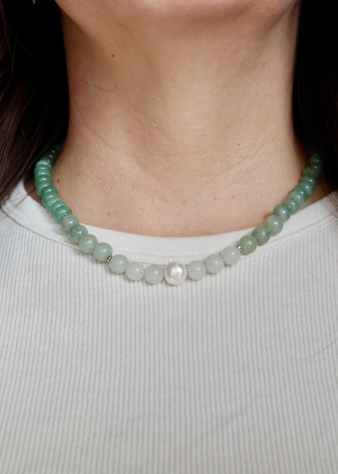 Meadowe jade and grape agate necklace worn at the collarbone, front view, with the freshwater pearl accent visible at the center of the strand