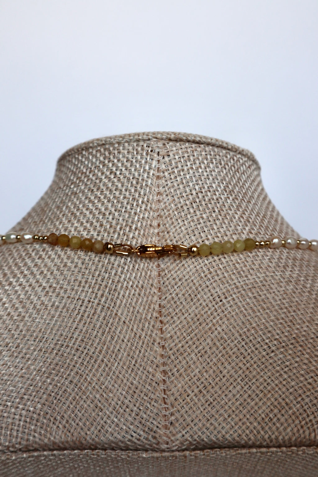 Auréad Designs Melline necklace back clasp detail showing gold stainless steel lobster clasp with yellow opal beads and freshwater rice pearls on linen bust form