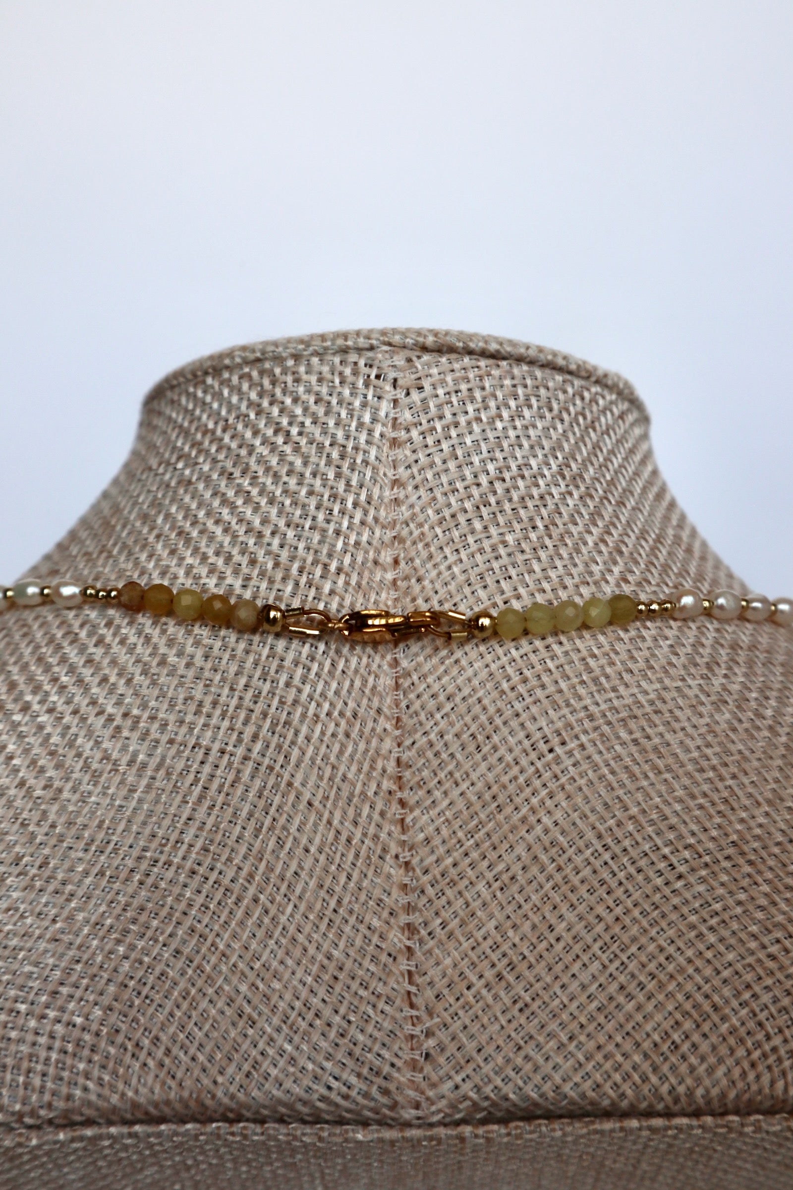 Auréad Designs Melline necklace back clasp detail showing gold stainless steel lobster clasp with yellow opal beads and freshwater rice pearls on linen bust form