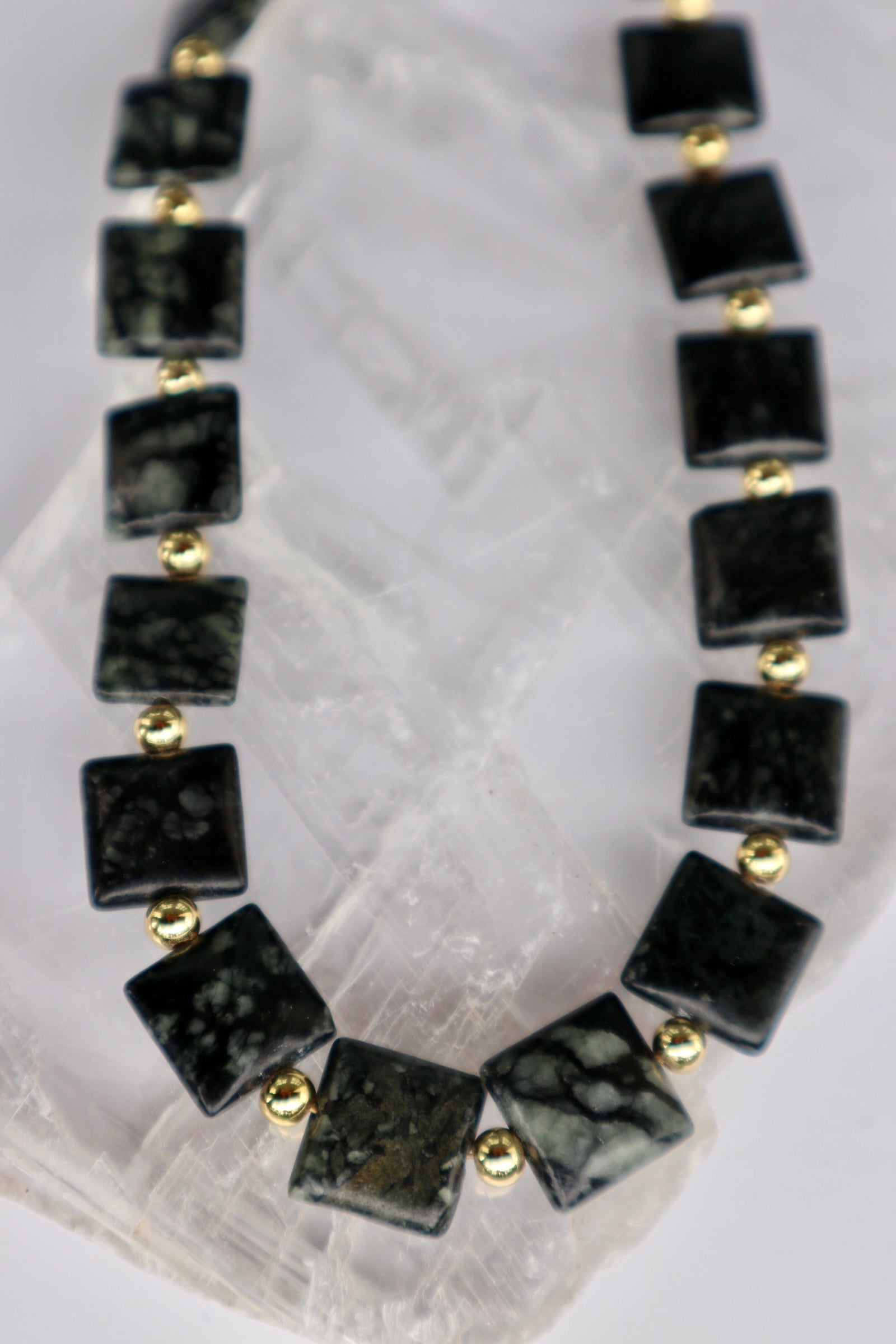 Close-up of the Morenne necklace showing the natural olive, charcoal, and neutral patterning of Picasso serpentine pillow beads alongside gold-filled spacer beads