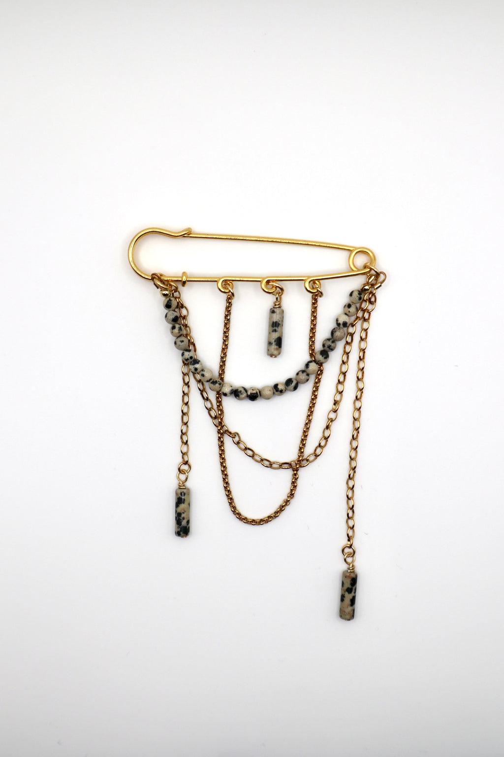 Perrin pin brooch by Auréad Designs showing the full design: Dalmatian jasper beads, safety pin-style closure, and cascading gold stainless steel chains
