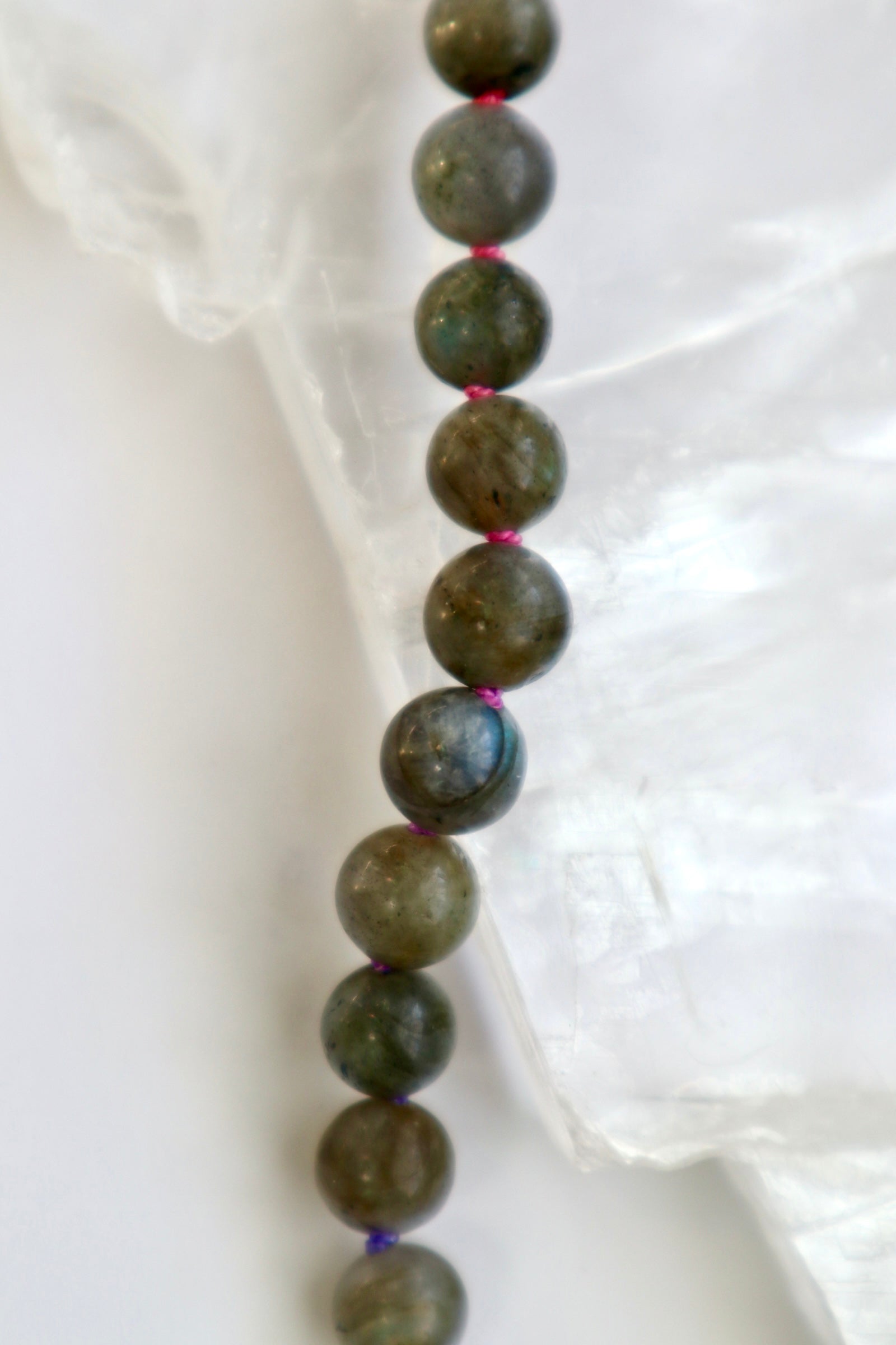 Prism labradorite and rainbow silk cord necklace by Auréad Designs worn on model, showcasing the play of color in the labradorite beads and the warmth of the multicolor ombré cord