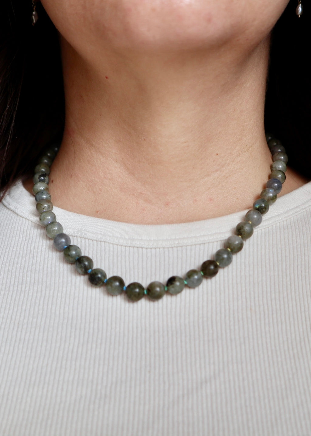 Prism labradorite necklace worn at the collarbone, front view, showing the multicolor ombré silk cord and the subtle blue and green flash of the labradorite beads