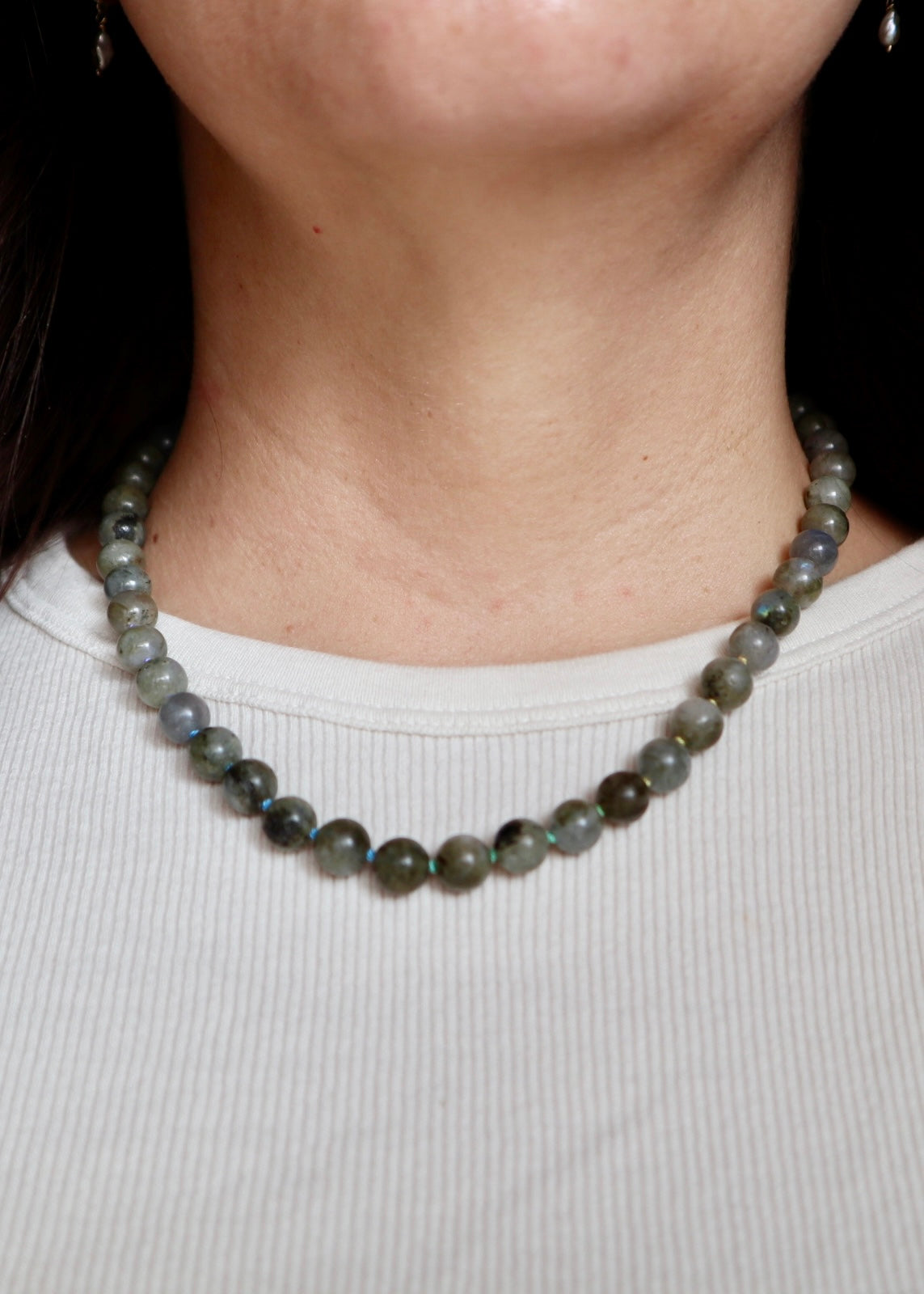 Prism labradorite necklace worn at the collarbone, front view, showing the multicolor ombré silk cord and the subtle blue and green flash of the labradorite beads