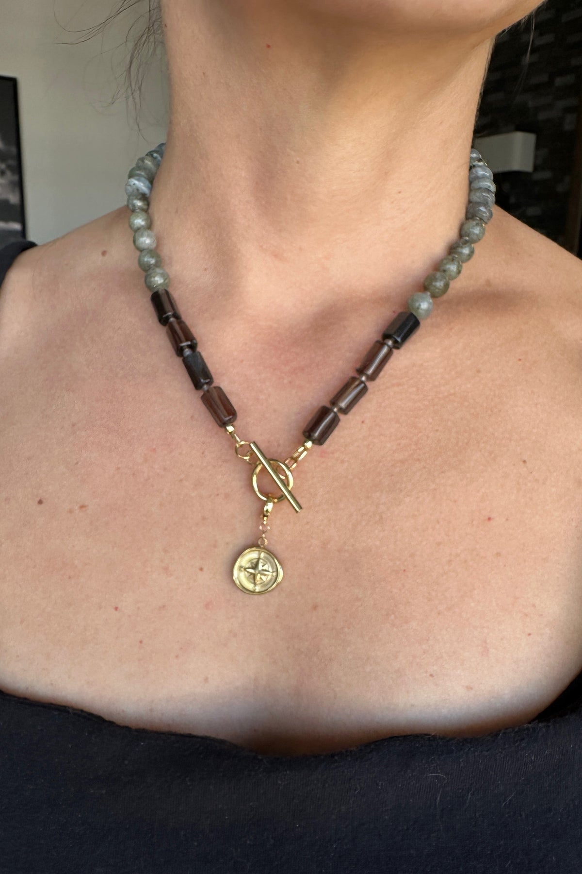 Ridge necklace by Auréad Designs worn with the gold compass charm toggle clasp as a front pendant, labradorite rondelles at the neckline transitioning to smoky quartz tubes