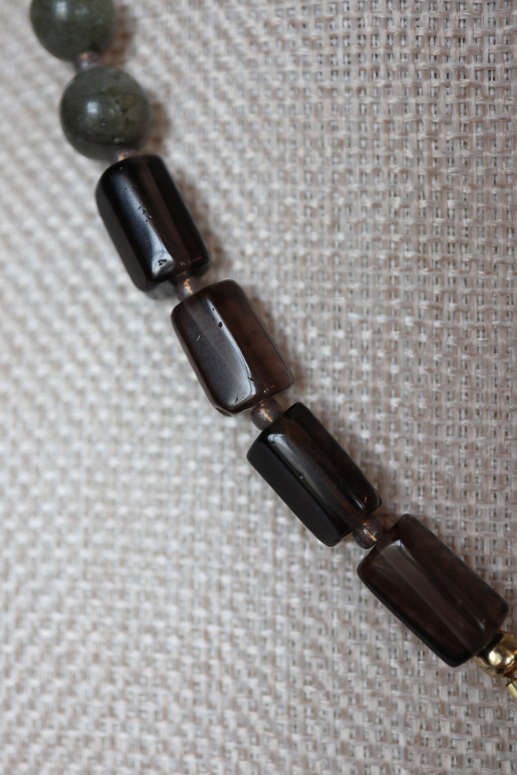 Close-up of smoky quartz tube beads on the Ridge necklace by Auréad Designs, showing the translucent dark brown-gray stone