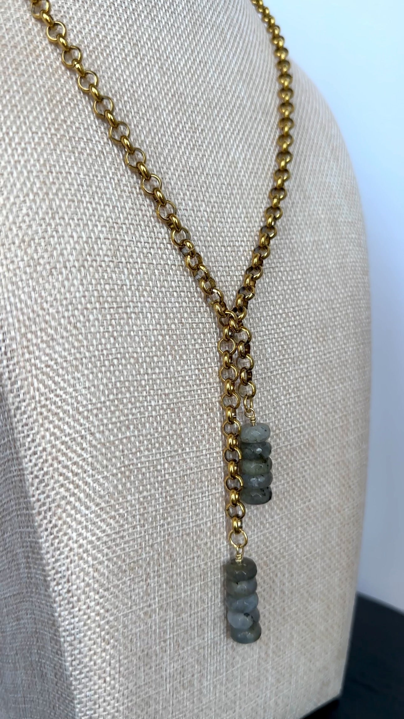 Auréad Designs Rochelle gold rolo chain lariat necklace displayed at an angle on a linen bust form, showing the 3.5-inch labradorite drop and chain drape.