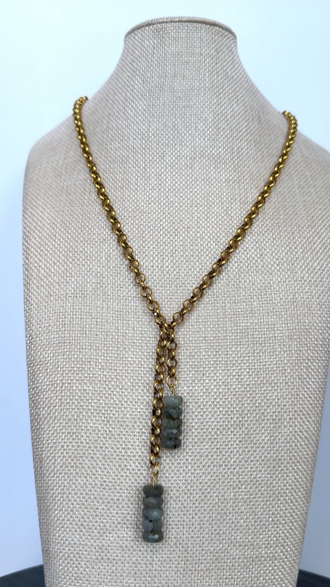 Auréad Designs Rochelle gold rolo chain lariat necklace with stacked labradorite rondelle drops displayed on a linen bust form, front view showing full drape.