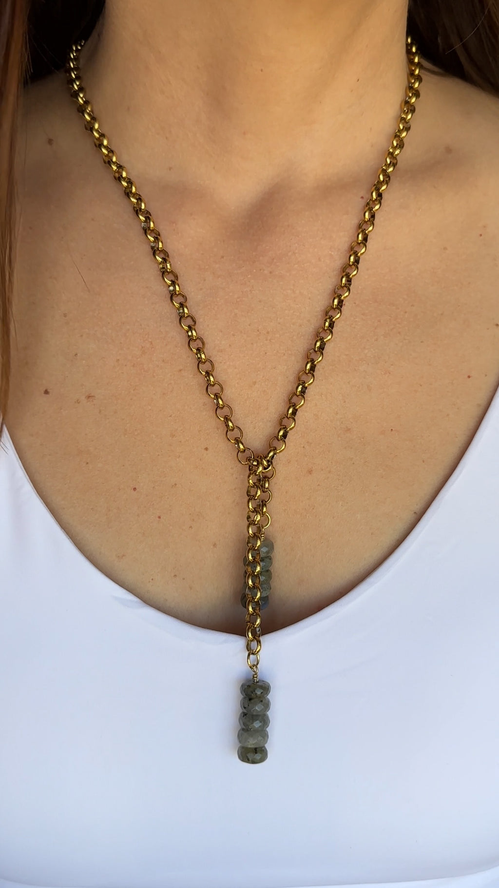 Auréad Designs Rochelle gold rolo chain lariat necklace with stacked labradorite drops worn at the chest over a white top, showing full lariat silhouette.