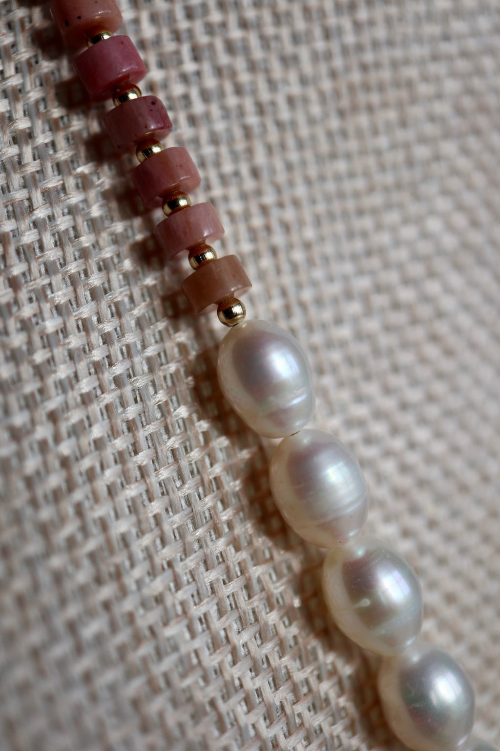 Close-up of the Rosera necklace showing the soft rose tones of rhodonite heishi beads alongside luminous freshwater pearls and galvanized gold spacer beads