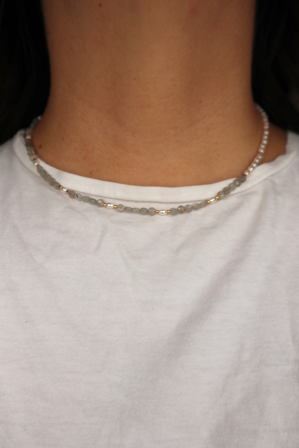 Selene labradorite and glass pearl necklace worn at the collarbone, front view, styled with a neutral top