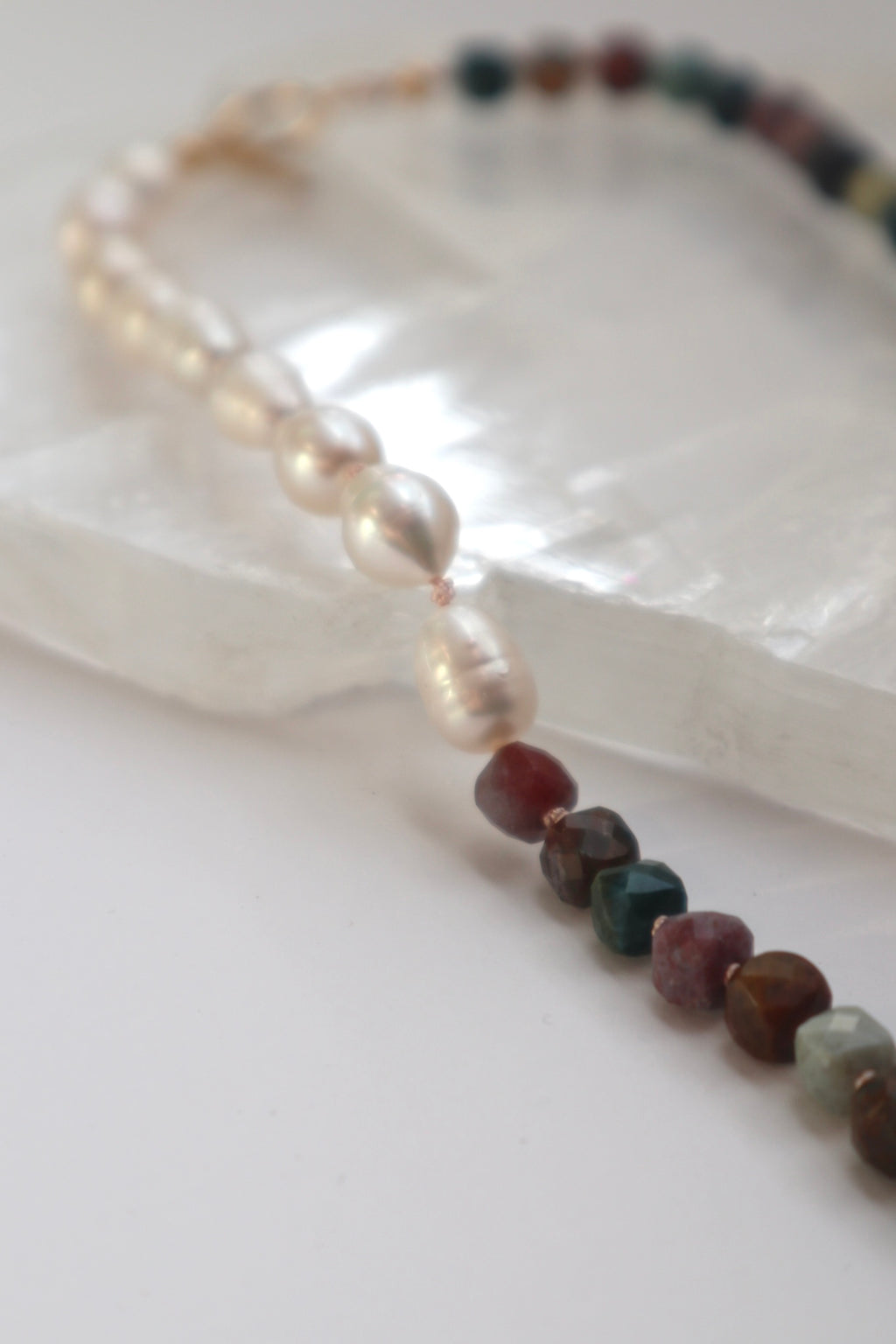 Close-up of the Siena necklace showing the natural marbling of Indian agate beads alongside luminous freshwater pearls on a silk-knotted strand
