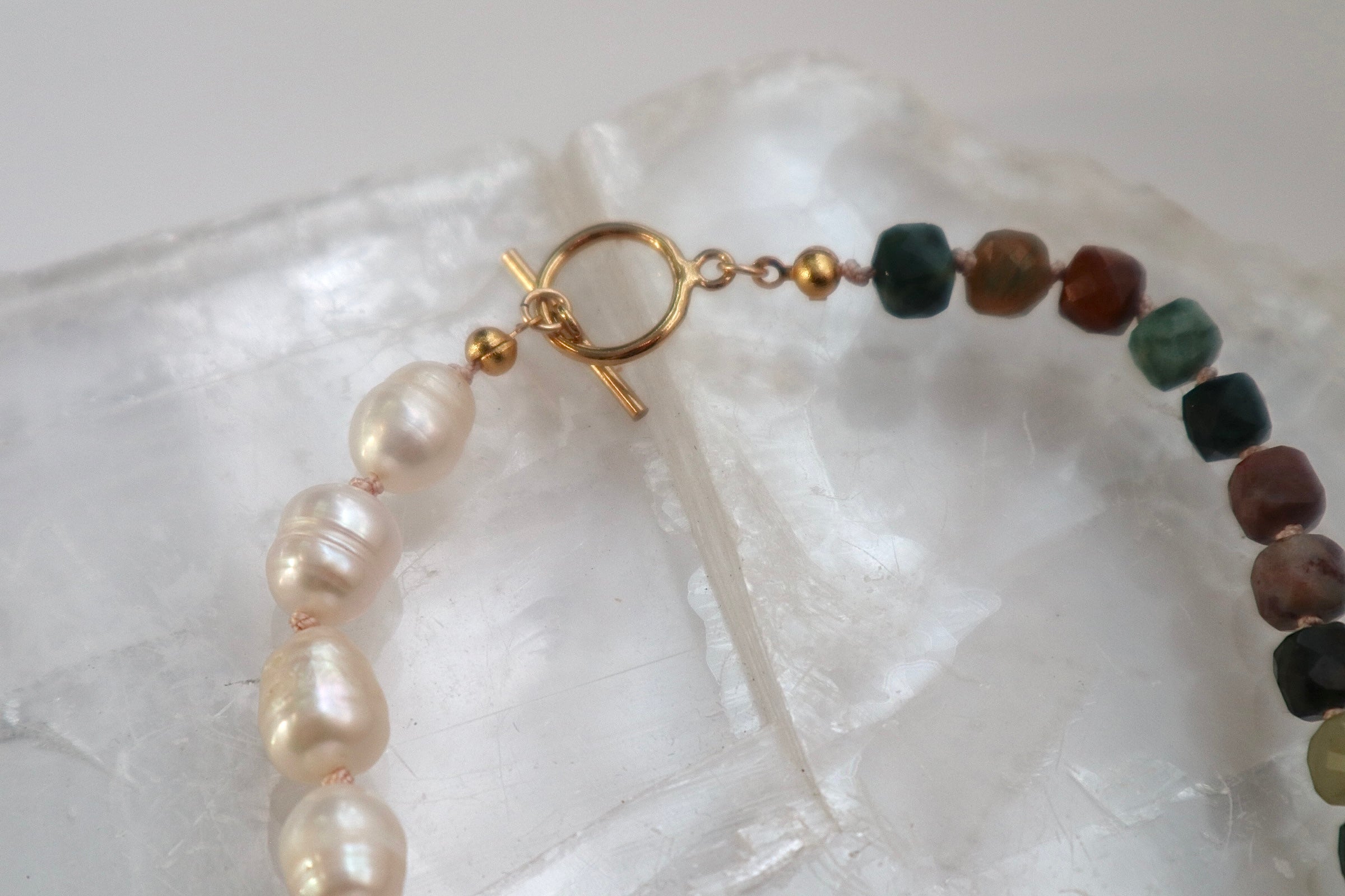 Detail shot of the Siena necklace highlighting the 14k gold-filled toggle clasp, silk knots between beads, and the contrast of Indian agate and freshwater pearl