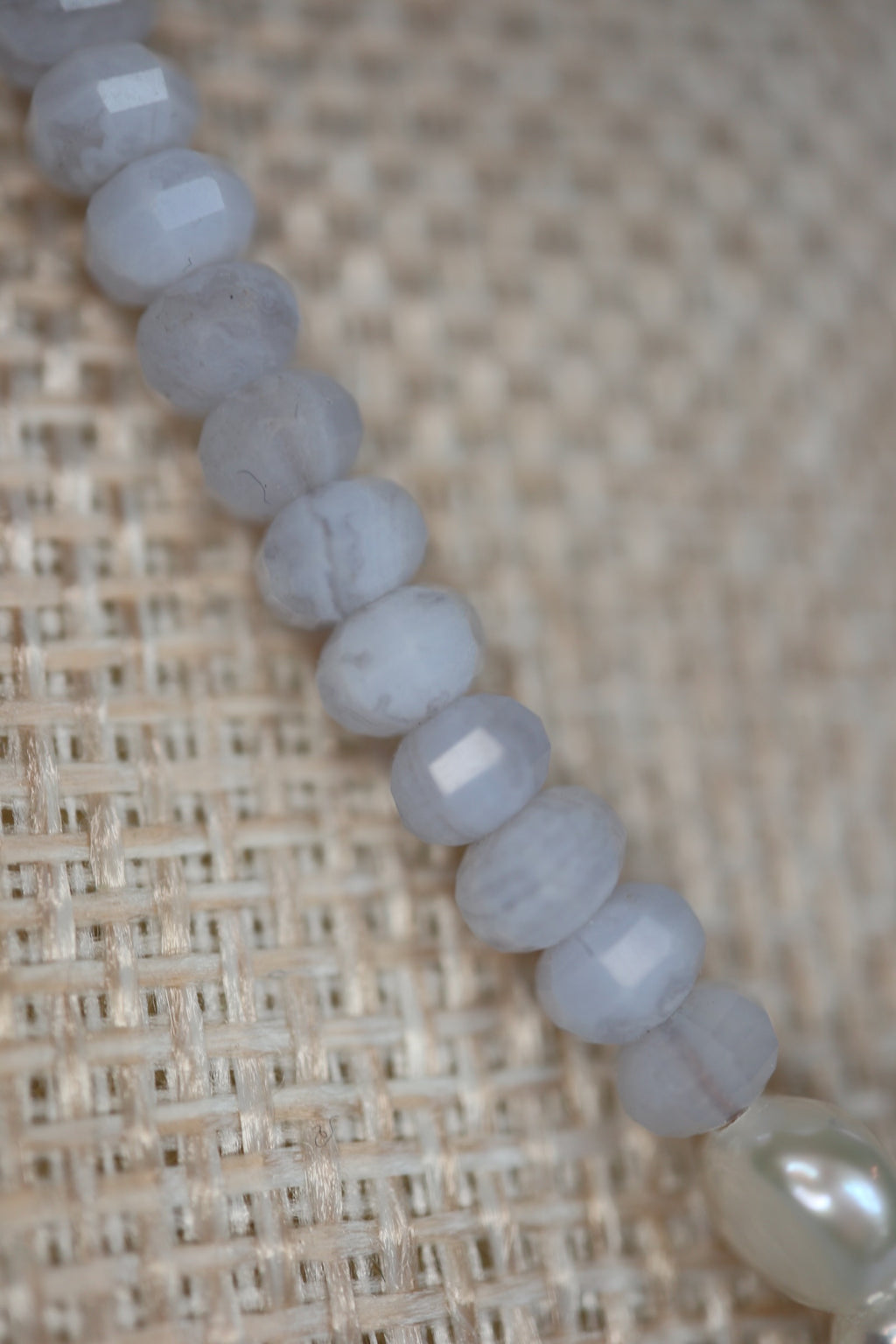 Close-up of faceted blue lace agate rondelle beads on the Sky necklace by Auréad Designs, showing the soft blue-gray color and delicate banding of the stone