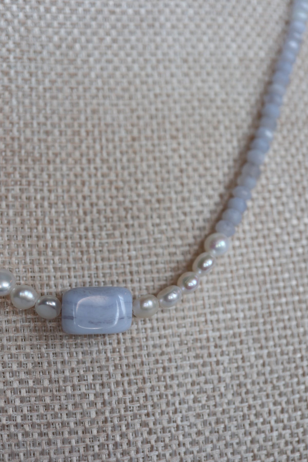 Close-up of the rectangular blue lace agate focal bead and freshwater pearl accents on the Sky necklace by Auréad Designs