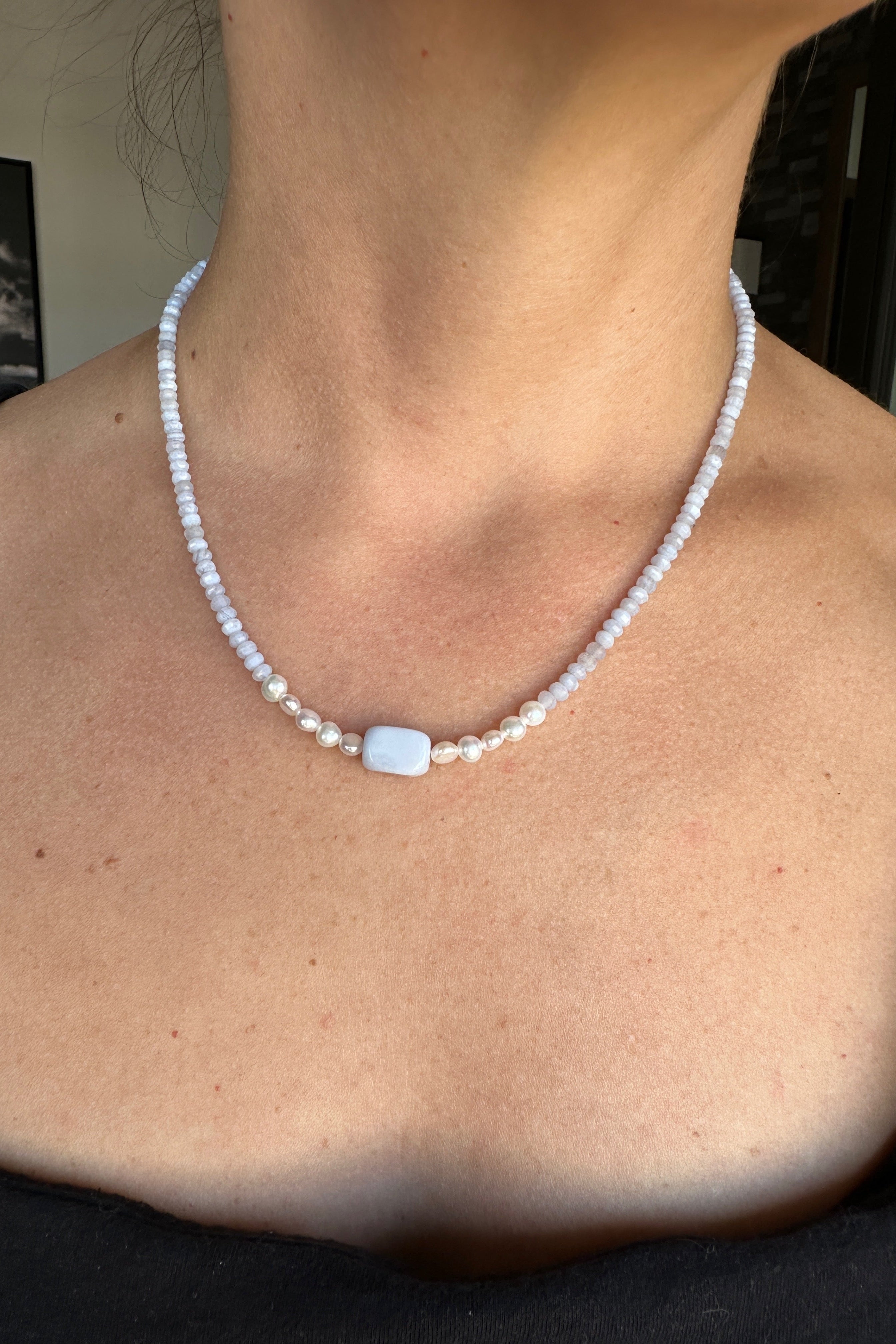 Sky necklace by Auréad Designs worn, showing the full piece with blue lace agate rondelles, freshwater pearl accents, and rectangular focal bead at center