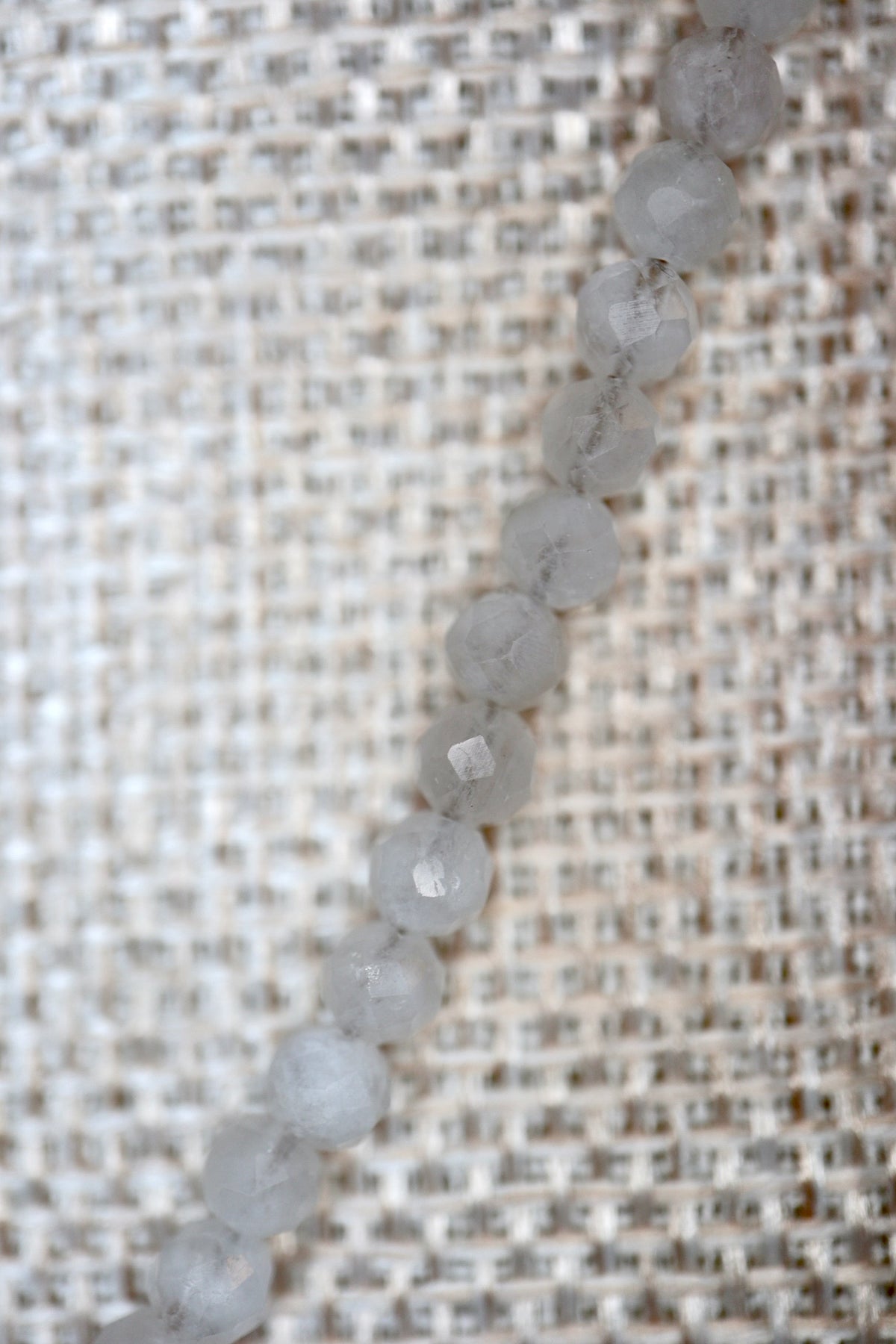 Close-up of faceted rainbow moonstone rondelle beads on the Snow necklace by Auréad Designs, showing the stone's soft white color and subtle shimmer