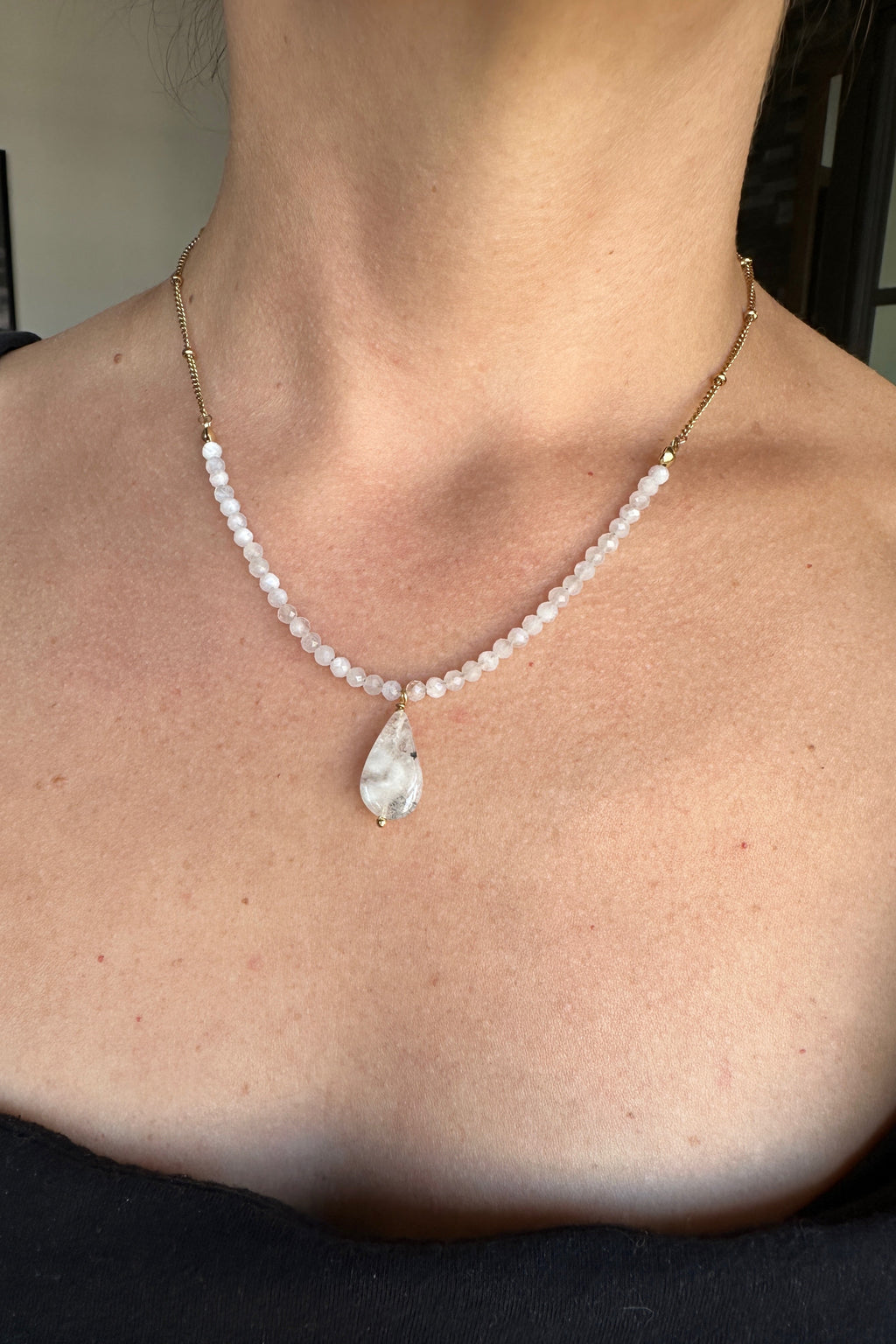Snow necklace by Auréad Designs worn, showing the full piece with rainbow moonstone rondelles, gold satellite chain, and moonstone teardrop pendant