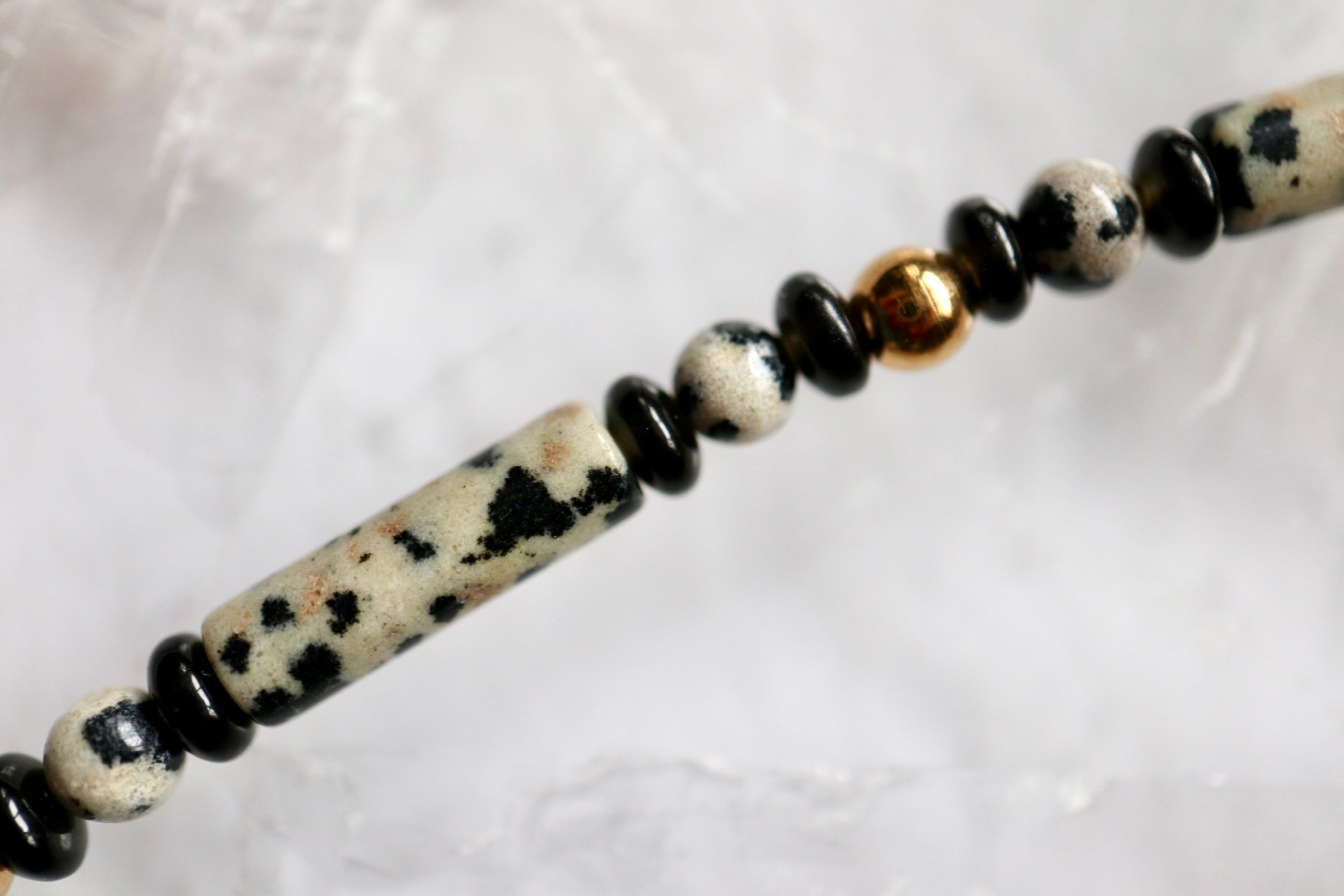 Close-up of the Sorren necklace showing the speckled pattern of dalmatian jasper beads alongside ice obsidian