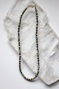 Sorren necklace by Auréad Designs, featuring dalmatian jasper and ice obsidian beads, laid flat on selenite slab