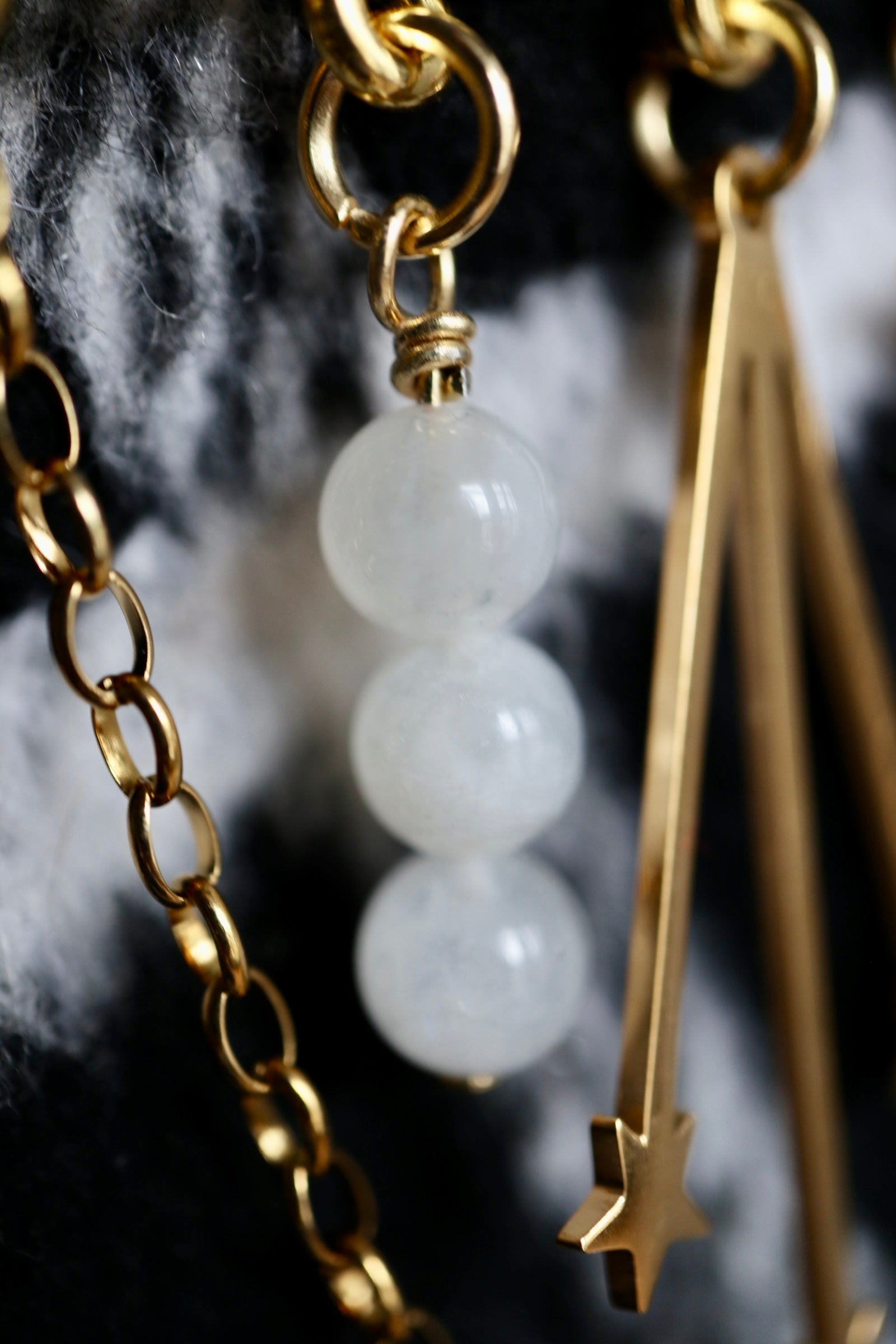 Close-up of the Stellune brooch showing moonstone beads and layered gold stainless steel chains with decorative charms