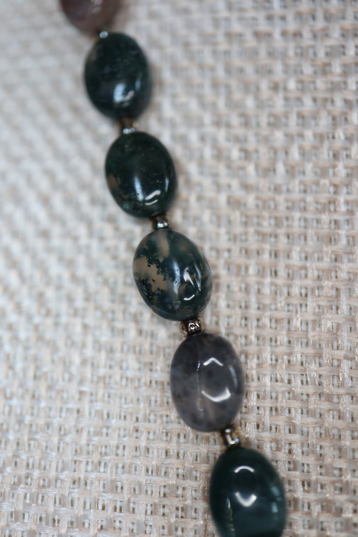Close-up of moss agate oval beads on the Trail necklace by Auréad Designs, showing the stone's deep green color and natural moss-like inclusions