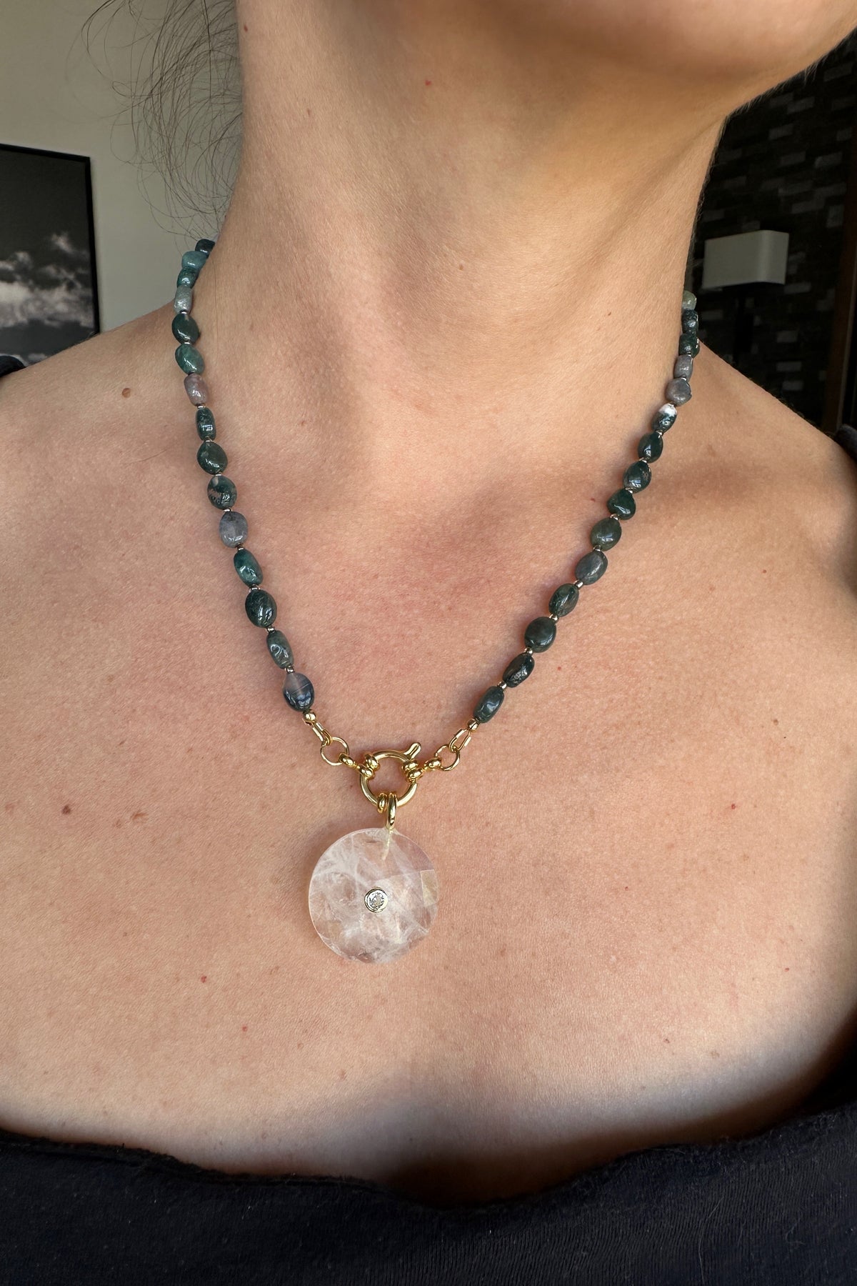 Trail necklace by Auréad Designs worn, showing the full piece with moss agate oval beads, gold ring clasp, and clear quartz donut pendant